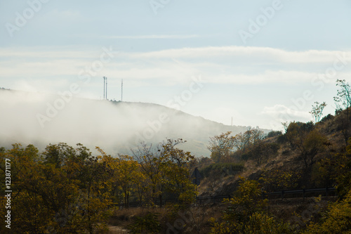 Montaña con niebla / Montaña cubierta de niebla con dos antenas de telefonía en la cima