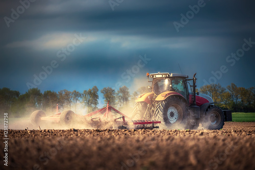 Farmer in tractor preparing land with seedbed cultivator