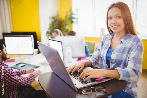 Happy businesswoman working with laptop