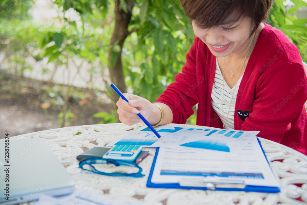 Top view of young working woman using laptop. Read a chart and graph outdoor. Top view of young working woman using laptop. Read a chart and graph outdoor.