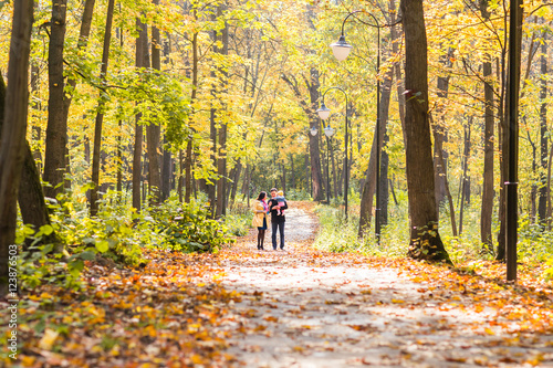 friendly family walking in the park in autumn together