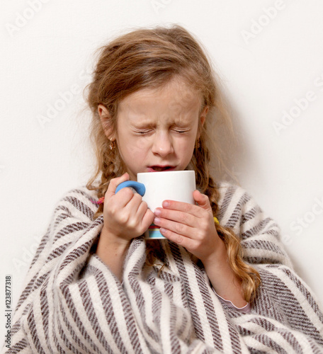 a little girl with a mug  temperature   illness  blanket
