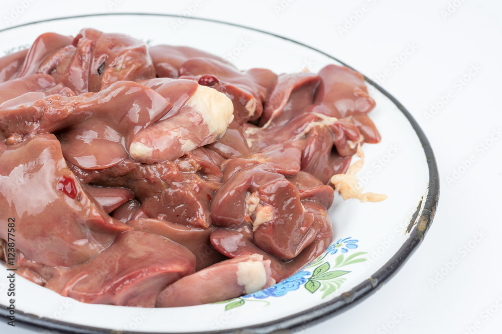Raw chicken liver in the metal plate over white