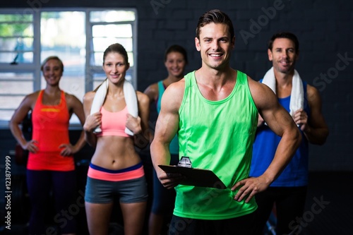 Smiling fitness instructor holding clipboard
