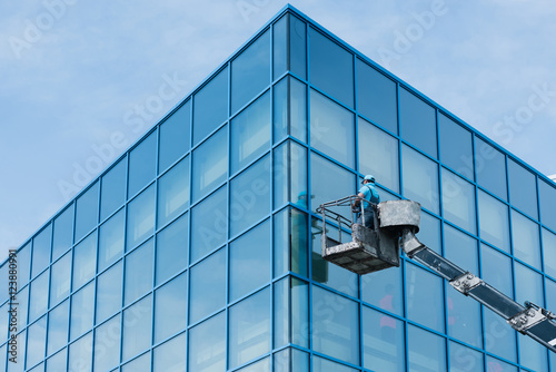 Fotografie Washer washing the windows of modern skyscraper