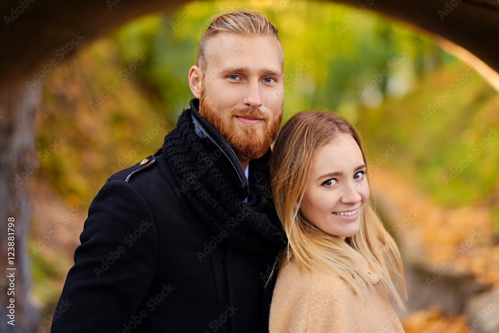 Fototapeta premium Redhead bearded male hugs the cute blonde female.