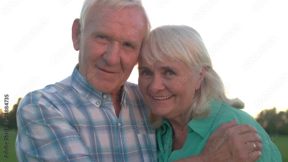 Senior man hugs woman. Smiling elderly couple outdoor. You're a gift of fate. Staying happy through the years. Senior man hugs woman. Smiling elderly couple outdoor. You're a gift of fate. Staying happy through the years.