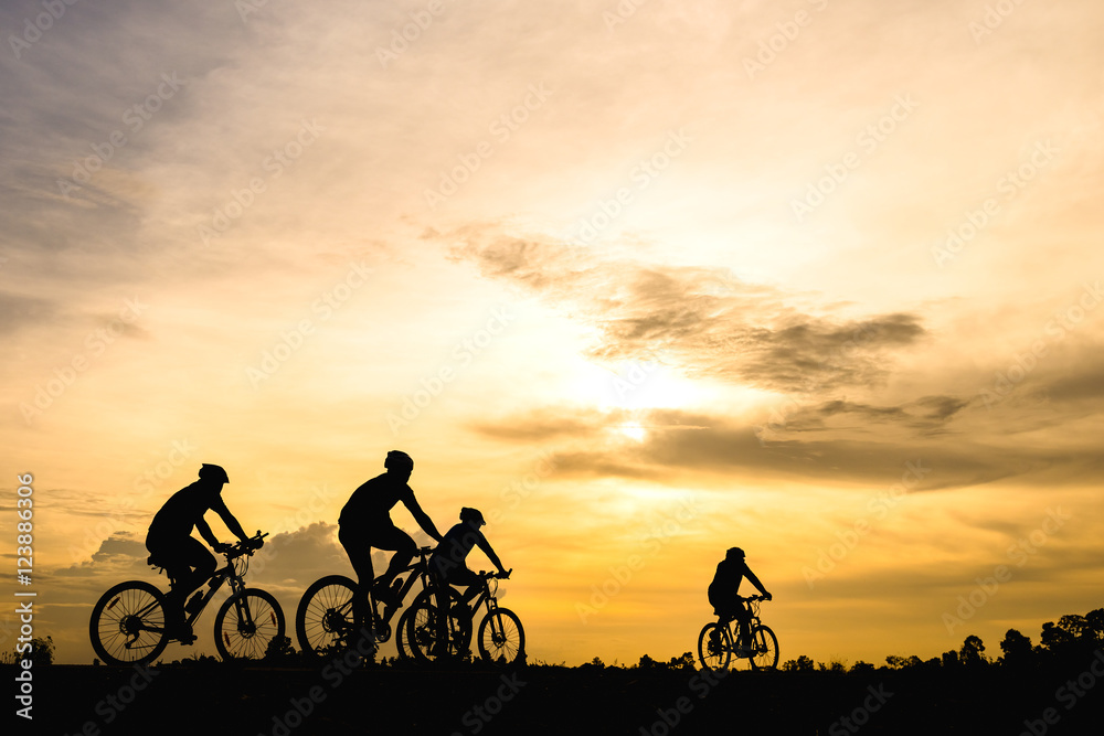 Silhouette of cyclist with friend motion on sunset background