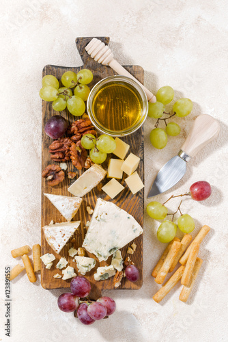 cheeseboard, fruits and honey on a white background, vertical 