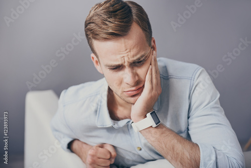 Fotografija Disappointed young man having toothache.
