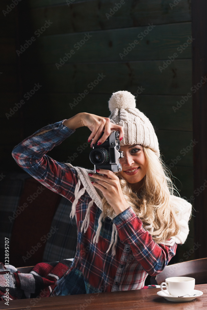 Young attractive woman in the cafe with camera