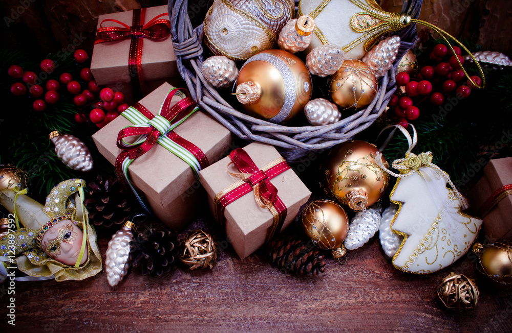 Fototapeta premium Christmas or New Year background: fur-tree, branches, gifts, colored glass balls, decoration and cones on wooden background