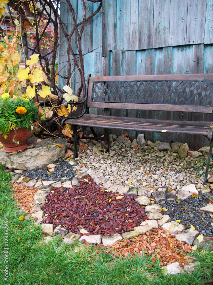 Bench and ornamental gravel in the late autumn rainy garden Stock Photo |  Adobe Stock