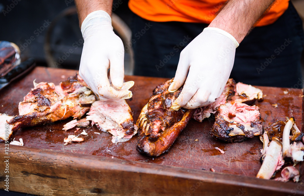 Hands cleaning Grilled spare beef or pork ribs from smoker.