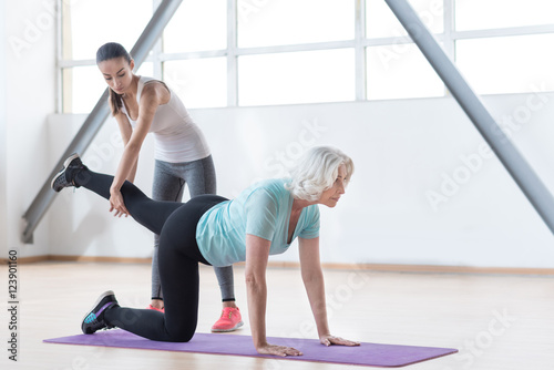 Serious slim woman doing a physical exercise