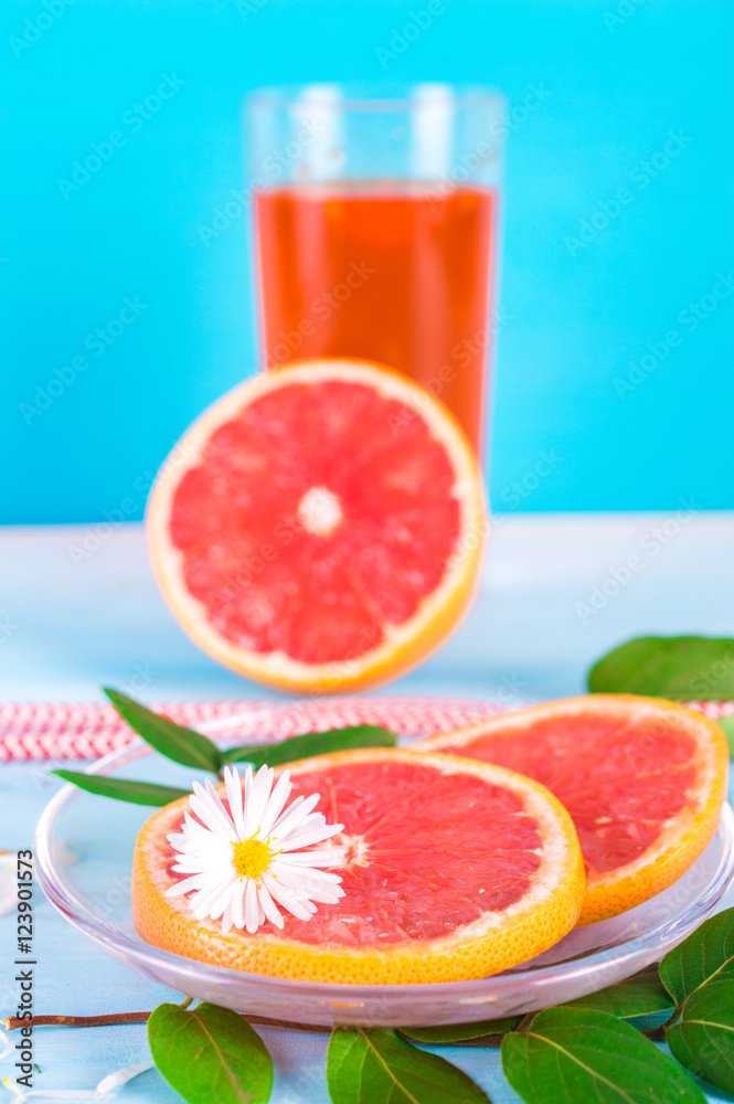 Grapefruit set. Juice, grapefruit slices, plate, tube. On blue, wooden background. Grapefruit set. Juice, grapefruit slices, plate, tube. On blue, wooden background.