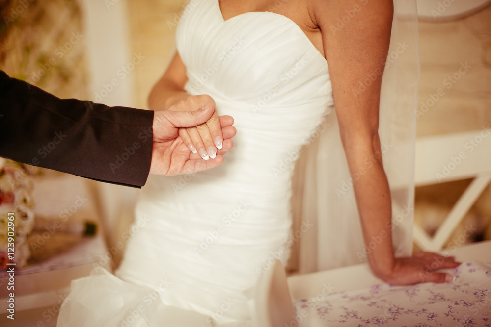 Groom holds bride's hand with french nails Groom holds bride's hand with french nails