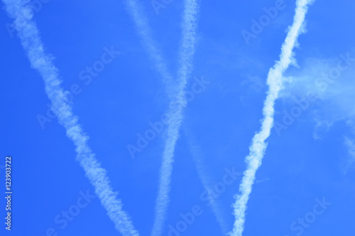 multiple jet streams of aiplane on blue skiy
 photo