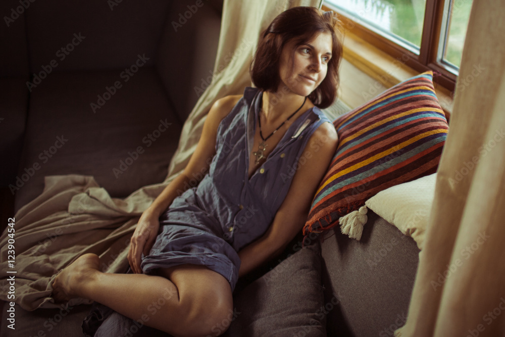 Young woman and cushions near the window Young woman and cushions near the window
