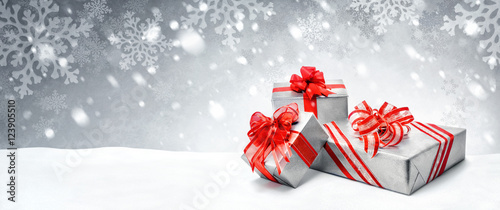Weihnachtsgeschenke in Rot und Silber auf Schnee Hintergrund