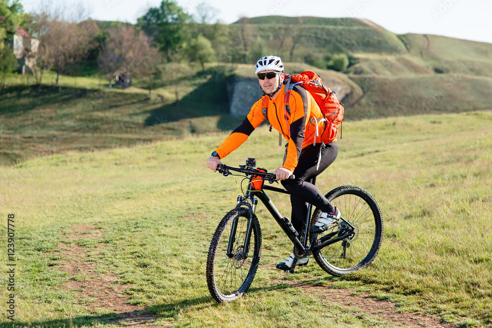 Young man standing with bicycle on an countryside