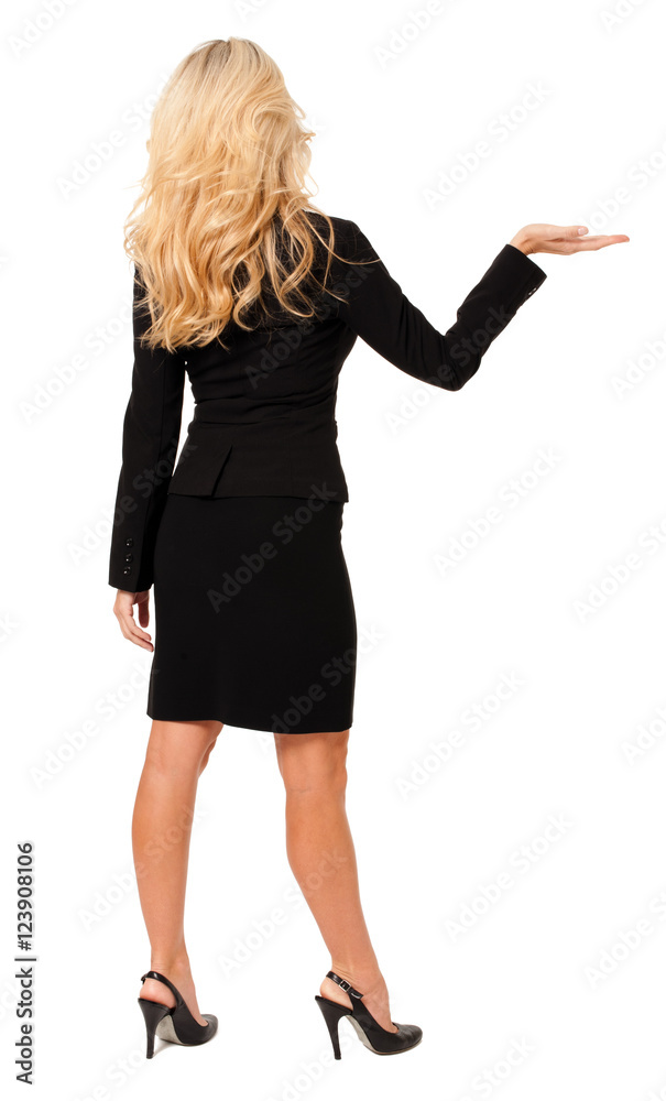 Full-length rear view from behind blond businesswoman gesturing holding showing presenting isolated on white background Full-length rear view from behind blond businesswoman gesturing holding showing presenting isolated on white background