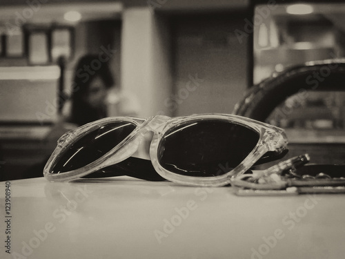 Fashion sun glass in table with a woman in shallow background