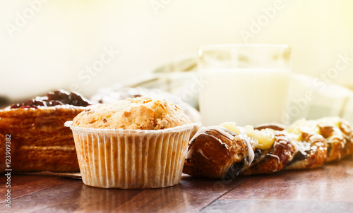 pastries, buns, custard cake, a glass of milk on the table. Close-up photo