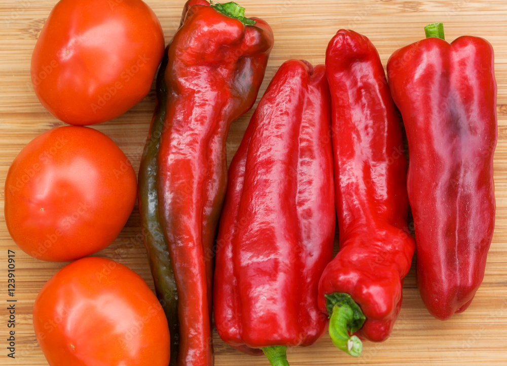 Red fresh pepper and tomato fruits on wooden Board
Red fresh pepper and tomato fruits on wooden Board