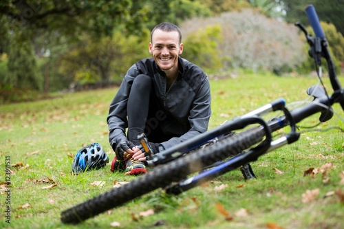 Male cyclist relaxing in park with mountain bike