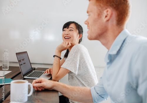 Two happy business people sitting at conference room