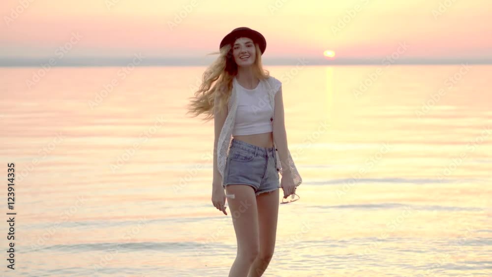 Young blonde girl in hat enjoying summer holidays on the ocean golden sunset 4K Young blonde girl in hat enjoying summer holidays on the ocean golden sunset 4K