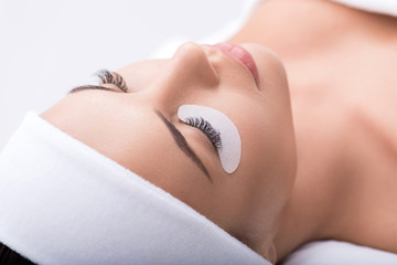 Beautiful young woman during eyelash extension