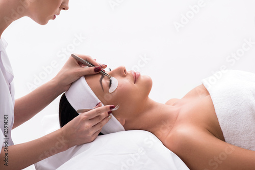 Billede på lærred Beautiful young woman during eyelash extension