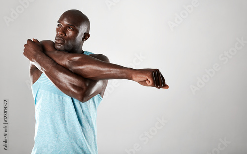 African man with muscular build stretching arms