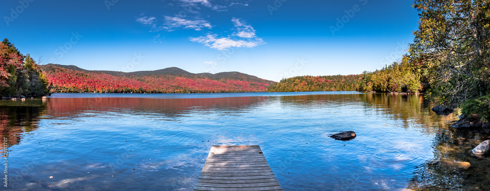 Obraz premium Panoramic view of Lake Placid in the Adirondacks on a bright sunny day with colorful autumn foliage