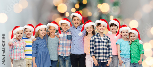 happy smiling children in santa hats hugging