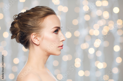 beautiful young woman face over holidays lights