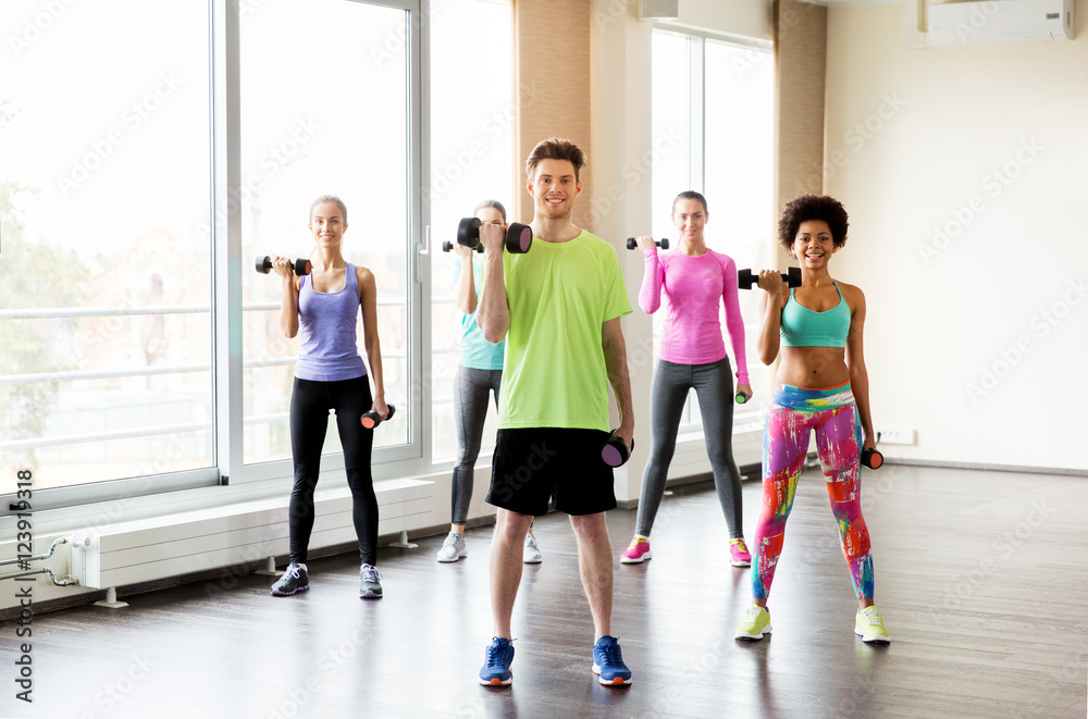 Fototapeta premium group of smiling people exercising with dumbbells