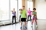 group of smiling people exercising with dumbbells