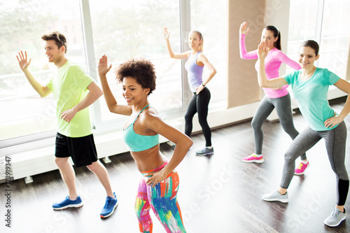 group of smiling people dancing in gym or studio © Syda Productions
