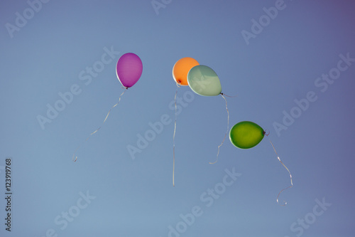 Colored balloons fly in the blue sky