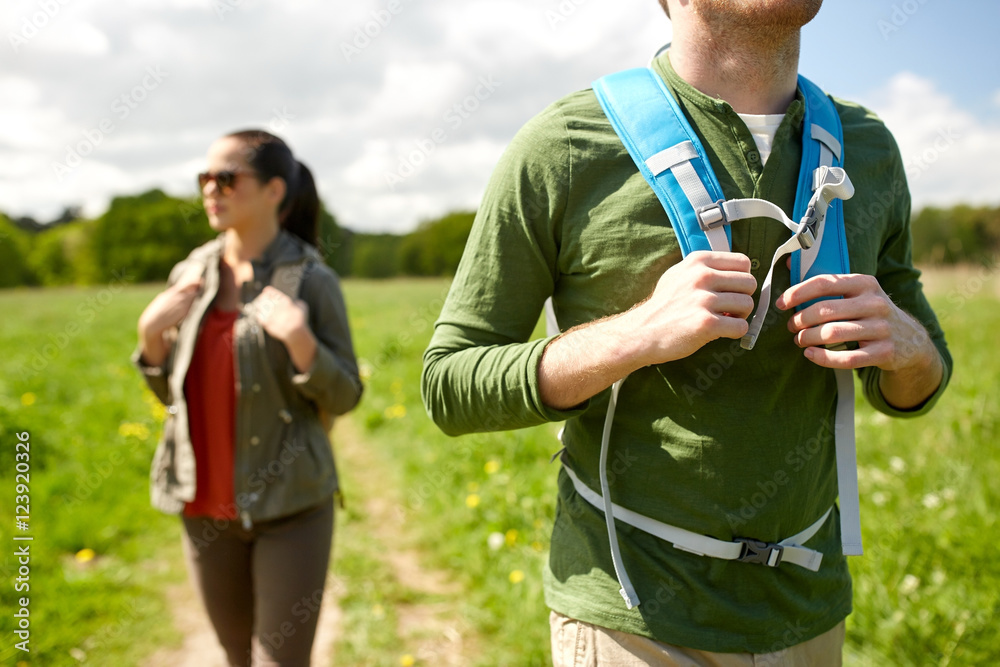 Naklejka premium close up of couple with backpacks hiking outdoors
