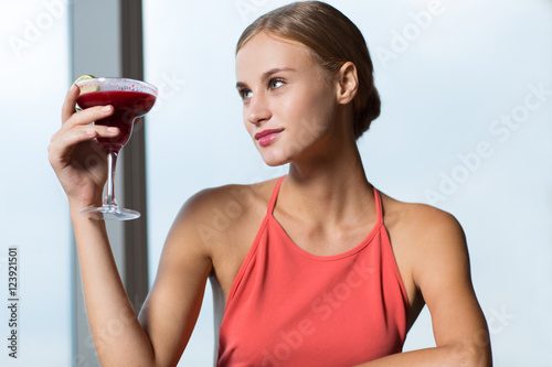 Foto Smiling Young Woman Raising Glass with Cocktail