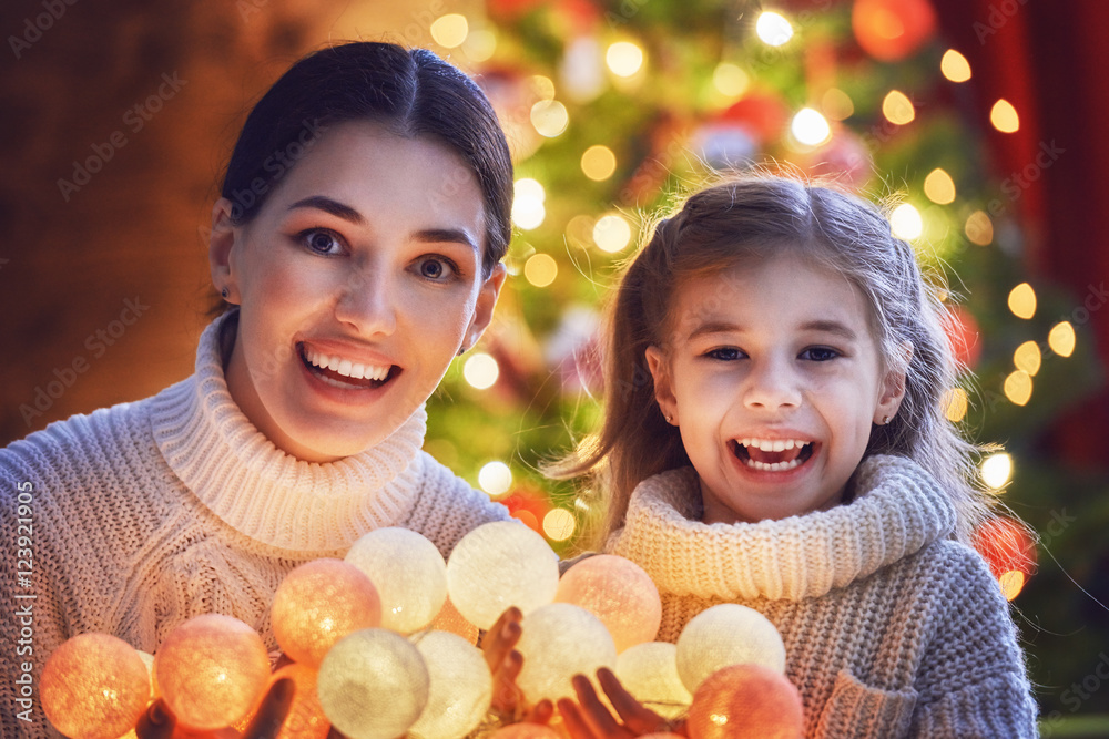 Mom and daughter decorate the Christmas tree. Mom and daughter decorate the Christmas tree.