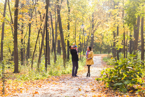 love, parenthood, family, season and people concept - smiling couple with baby in autumn park