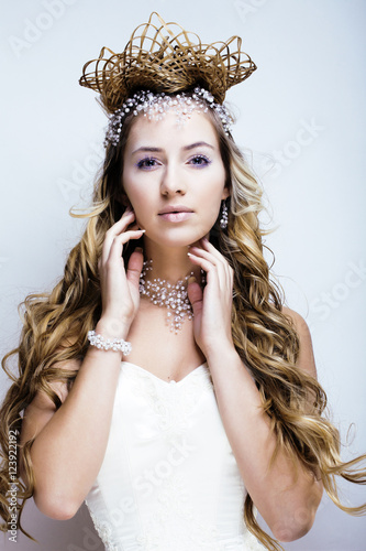 beauty young snow queen with hair crown on her head, complicate 