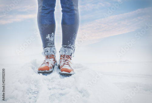 Legs of traveler standing in snow outdoor. Travel and discovery