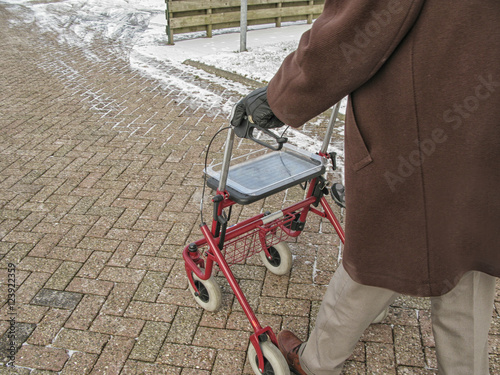 Senior behind wheeled walker photo