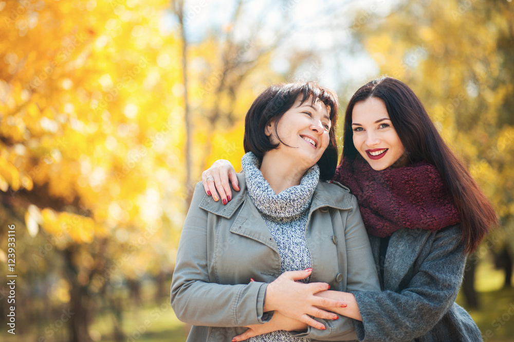 Fototapeta premium Portrait of seniour mother and adult beautiful daughter in the park are hugging and smiling